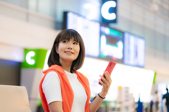 ドイツの空港でスマホを見る女性