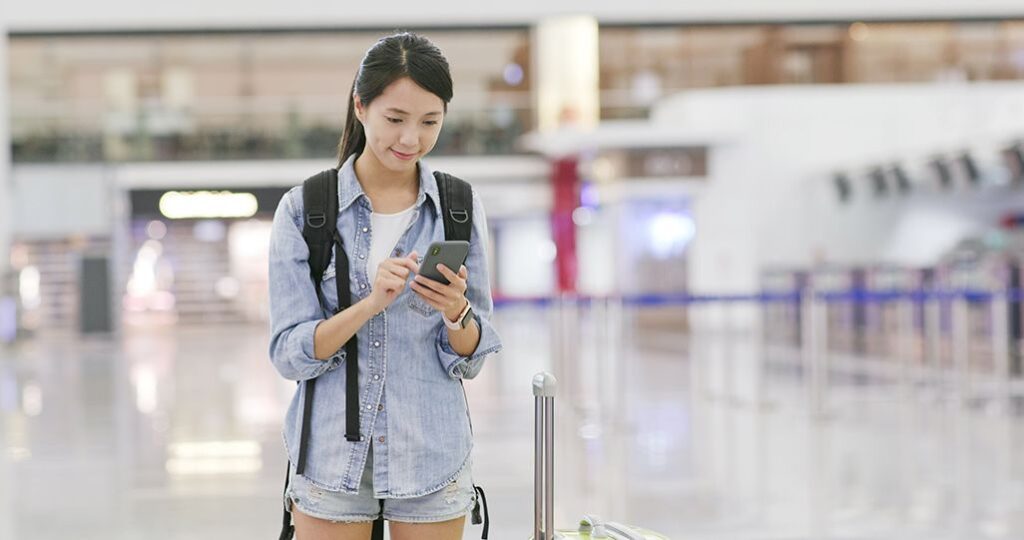 中国の空港でスマを使用する女性