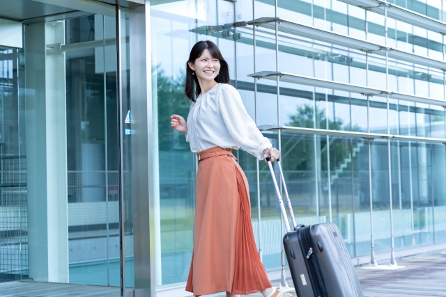 羽田空港で借りられるWi-FIレンタルサービスについて調べる女性
