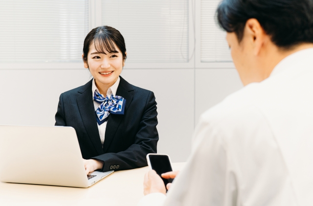 イモトのWiFiを成田空港で受け取れるカウンターで働く女性