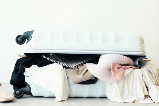 海外旅行に持っていかない方がよいものがはみ出たスーツケース