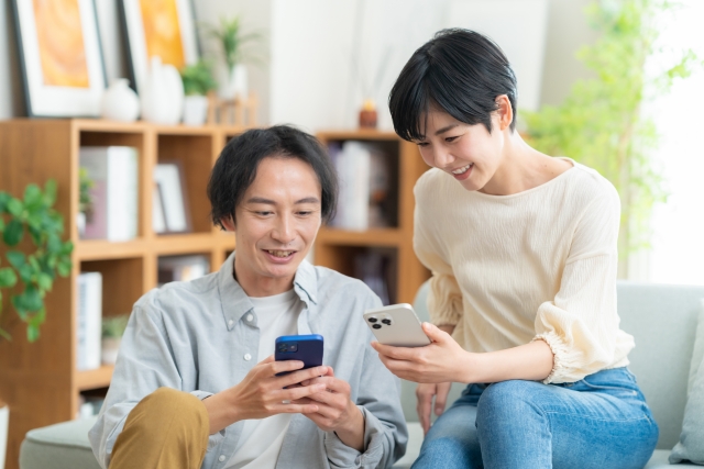 ahamoはグアムで使えるのか調べるカップル