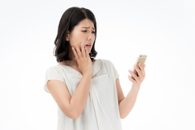 海外でスマホ決済できるか悩む女性